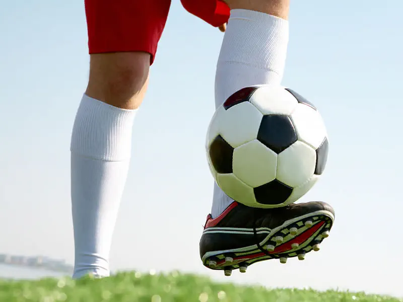 Niños jugando fútbol en equipo